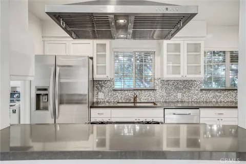 a kitchen with granite countertop a refrigerator and a sink