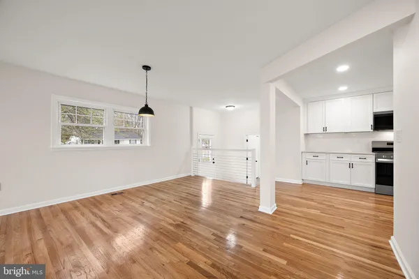 a view of a kitchen with wooden floor and a window
