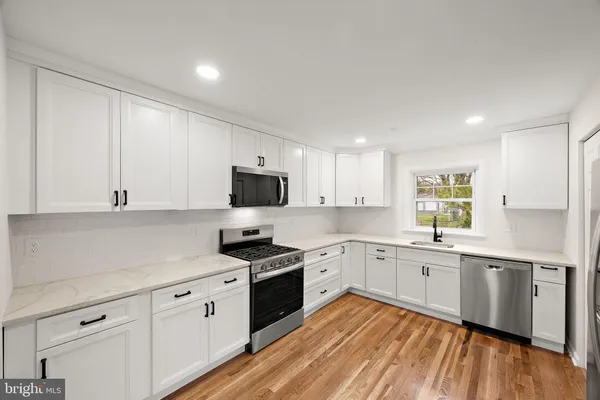 a kitchen with granite countertop white cabinets and white appliances