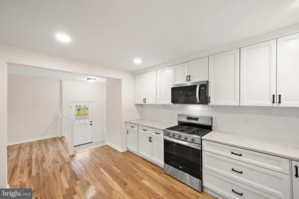 a kitchen with granite countertop a stove a sink and a refrigerator