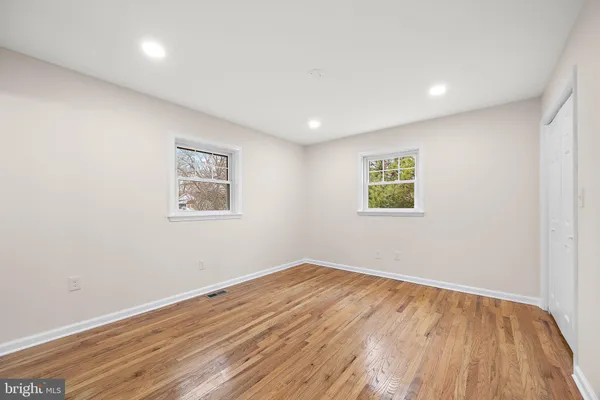 a view of empty room with wooden floor