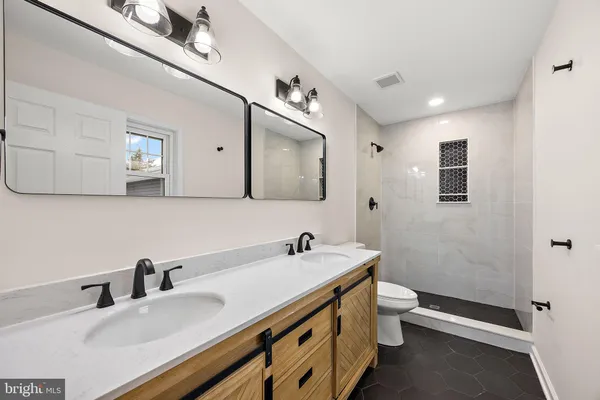 a bathroom with a double vanity sink and a mirror