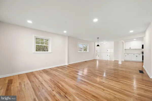 a view of empty room with wooden floor and windows