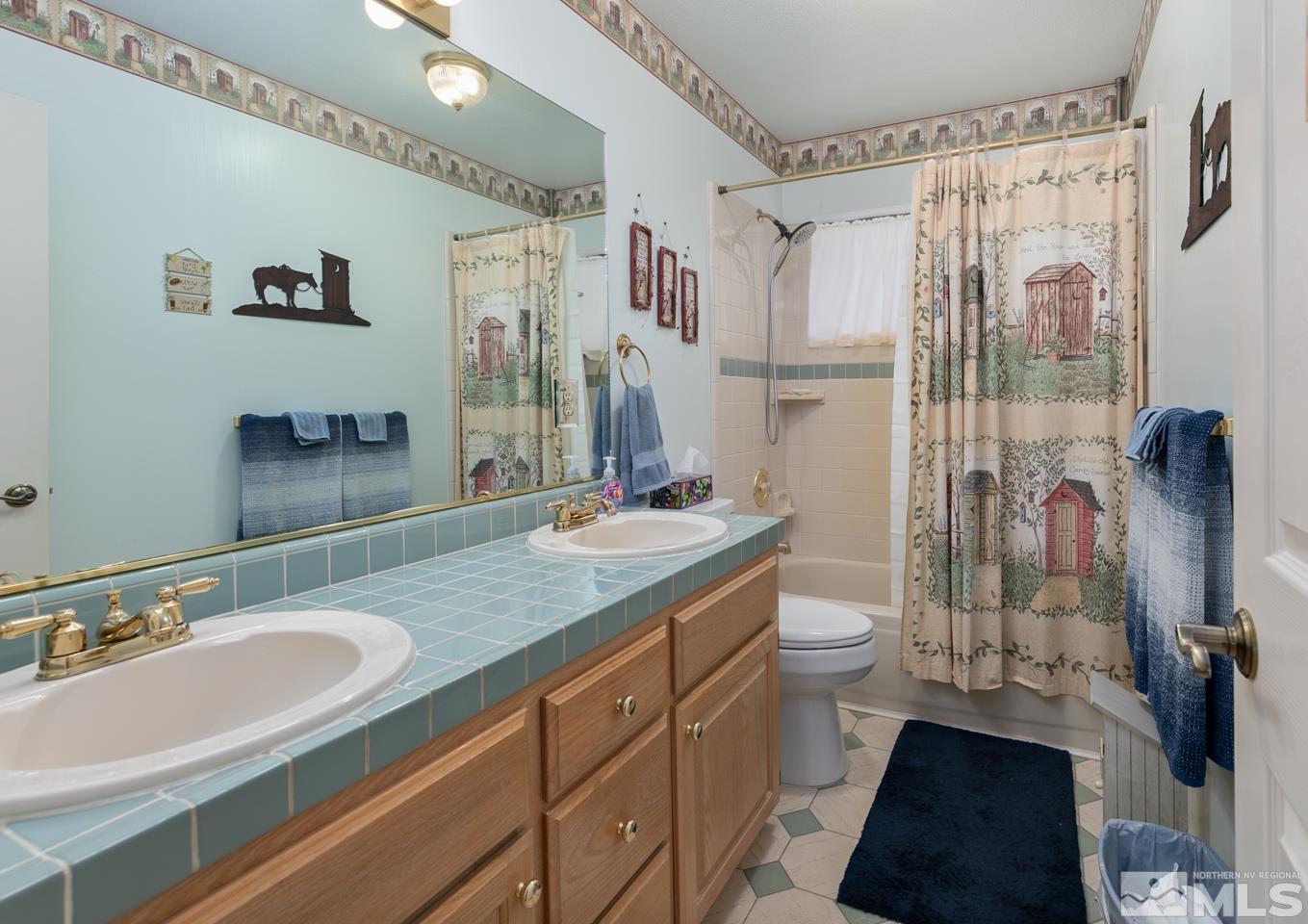 3812 Boyer Road Fallon, NV 89406 - Photo 9 of 40 a bathroom with a granite countertop sink toilet a mirror a vanity and shower