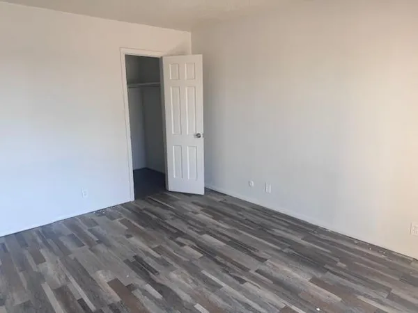 a view of an empty room with wooden floor