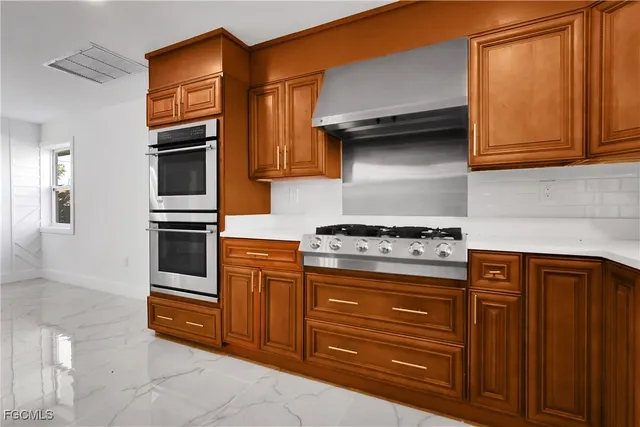 a kitchen with stainless steel appliances granite countertop a stove and a refrigerator