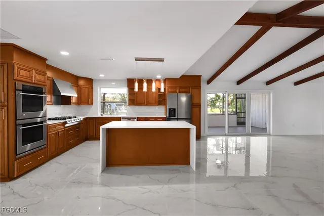 a large kitchen with stainless steel appliances granite countertop a large stove a sink dishwasher and a refrigerator