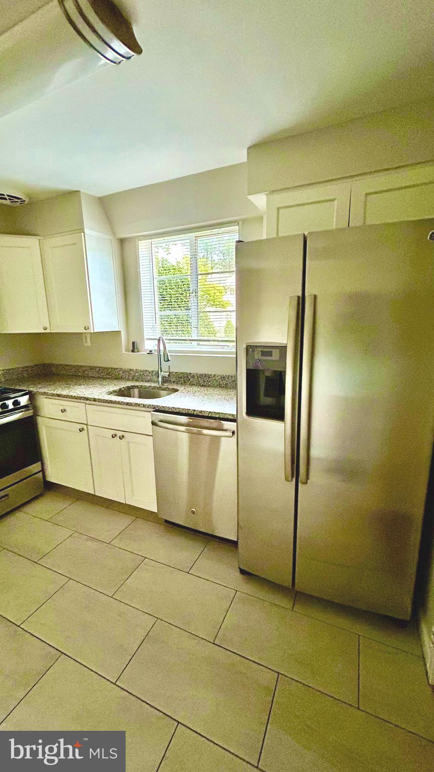 5319 Pooks Hill Road, Unit 1 Bethesda, MD 20814 - Photo 9 of 37 a kitchen with stainless steel appliances granite countertop a refrigerator a sink a stove a microwave and island