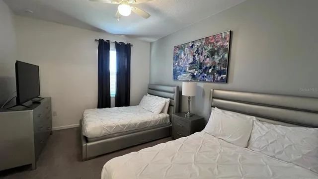 a bedroom with two beds and a flat screen tv