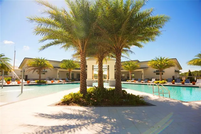 a view of swimming pool with outdoor seating and house in the background