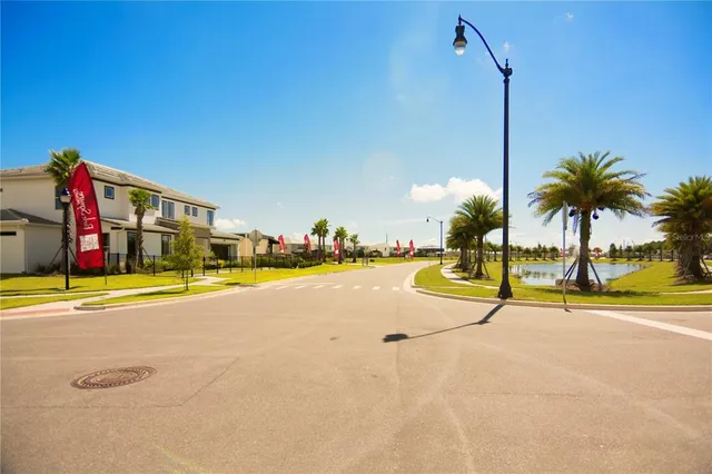 a view of a house with a yard and palm trees