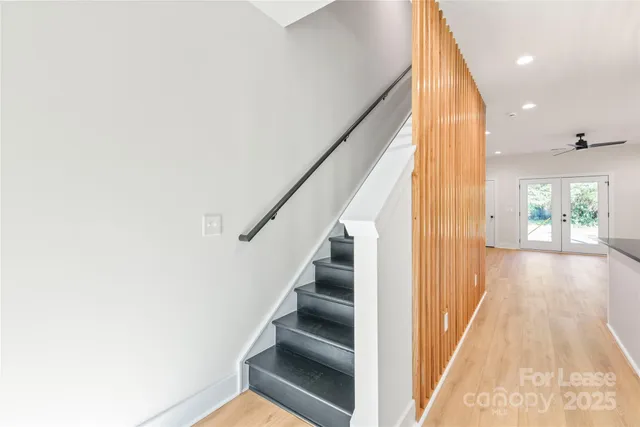 a view of a hallway with wooden floor and staircase