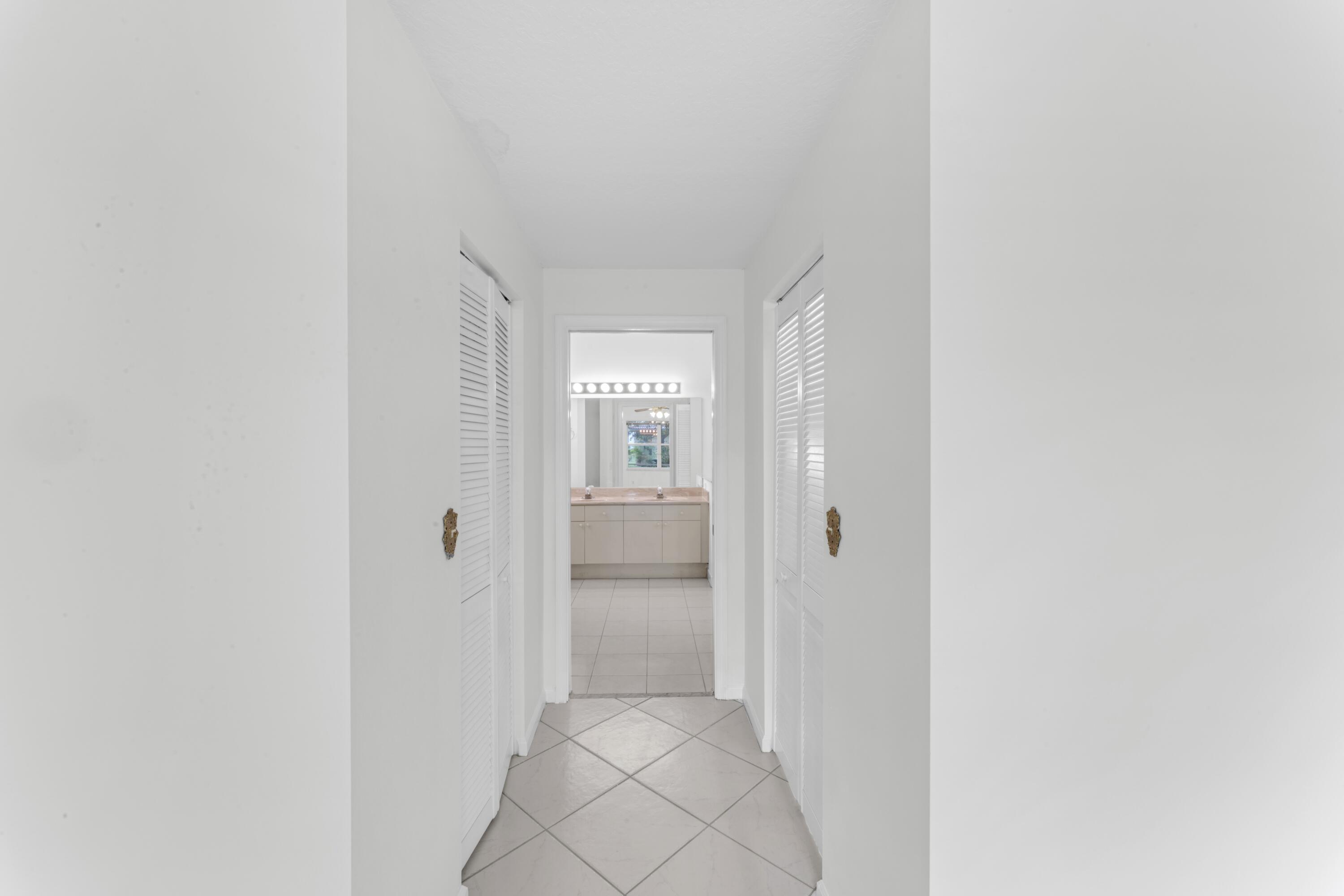 2705 Pointe Circle Greenacres, FL 33413 - Photo 16 of 46 Primary closets from bedroom to bathroom