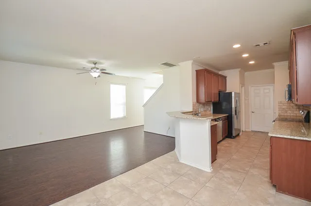 an empty room with a window and a fan