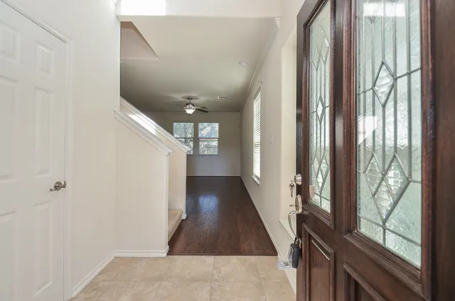 a view of an empty room with window and wooden floor