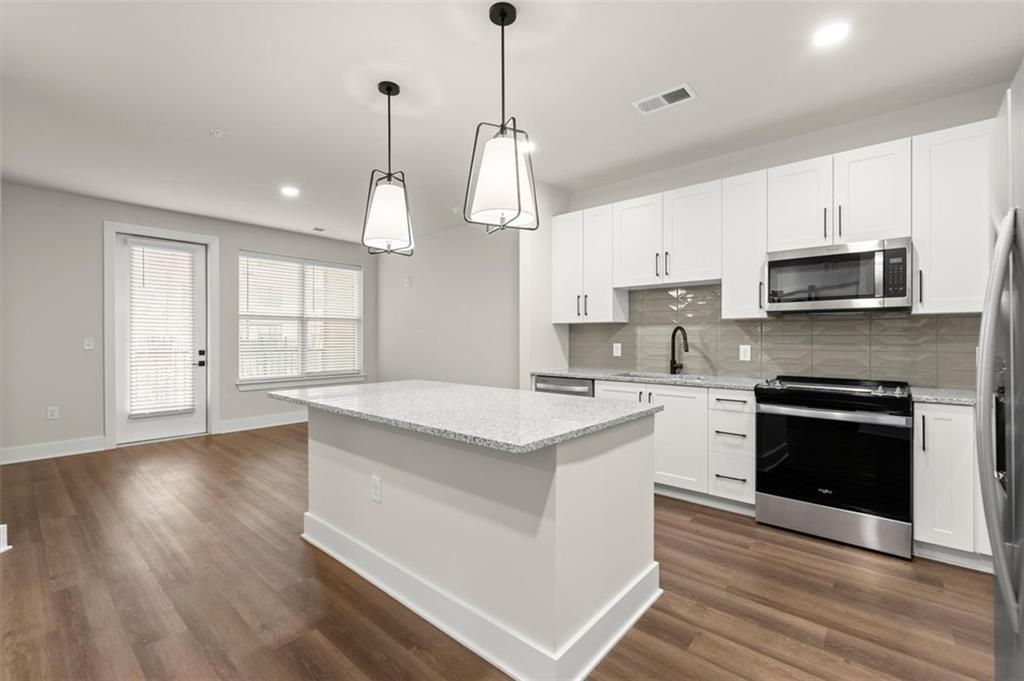2648 Sandy Plains Road, Unit 137 Marietta, GA 30062 - Photo 2 of 38 a kitchen with stainless steel appliances granite countertop a stove a sink dishwasher a refrigerator white cabinets and wooden floor