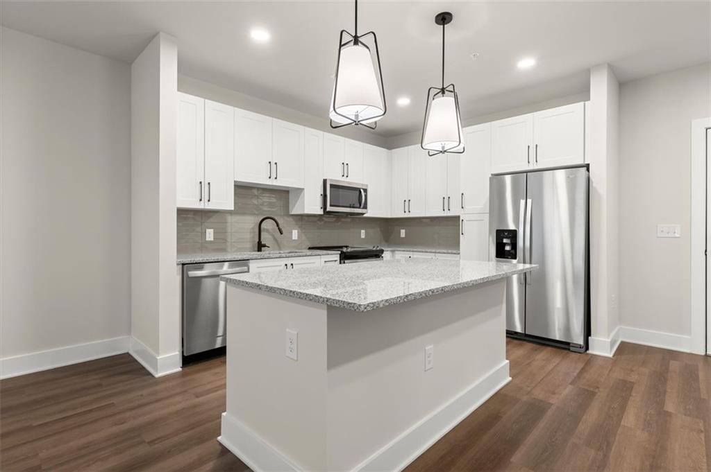 2648 Sandy Plains Road, Unit 137 Marietta, GA 30062 - Photo 3 of 38 a kitchen with stainless steel appliances granite countertop a refrigerator a sink dishwasher a stove and white cabinets with wooden floor