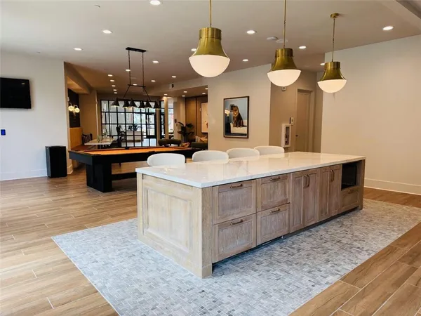 a large white kitchen with a large island oven a stove and a wooden floors