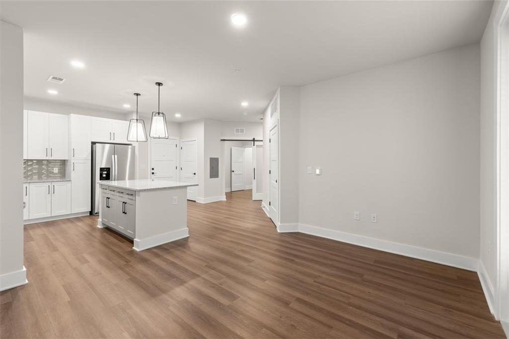 2648 Sandy Plains Road, Unit 137 Marietta, GA 30062 - Photo 7 of 38 a large kitchen with a wooden floor and white stainless steel appliances