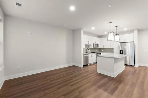 a view of kitchen with wooden floor and electronic appliances