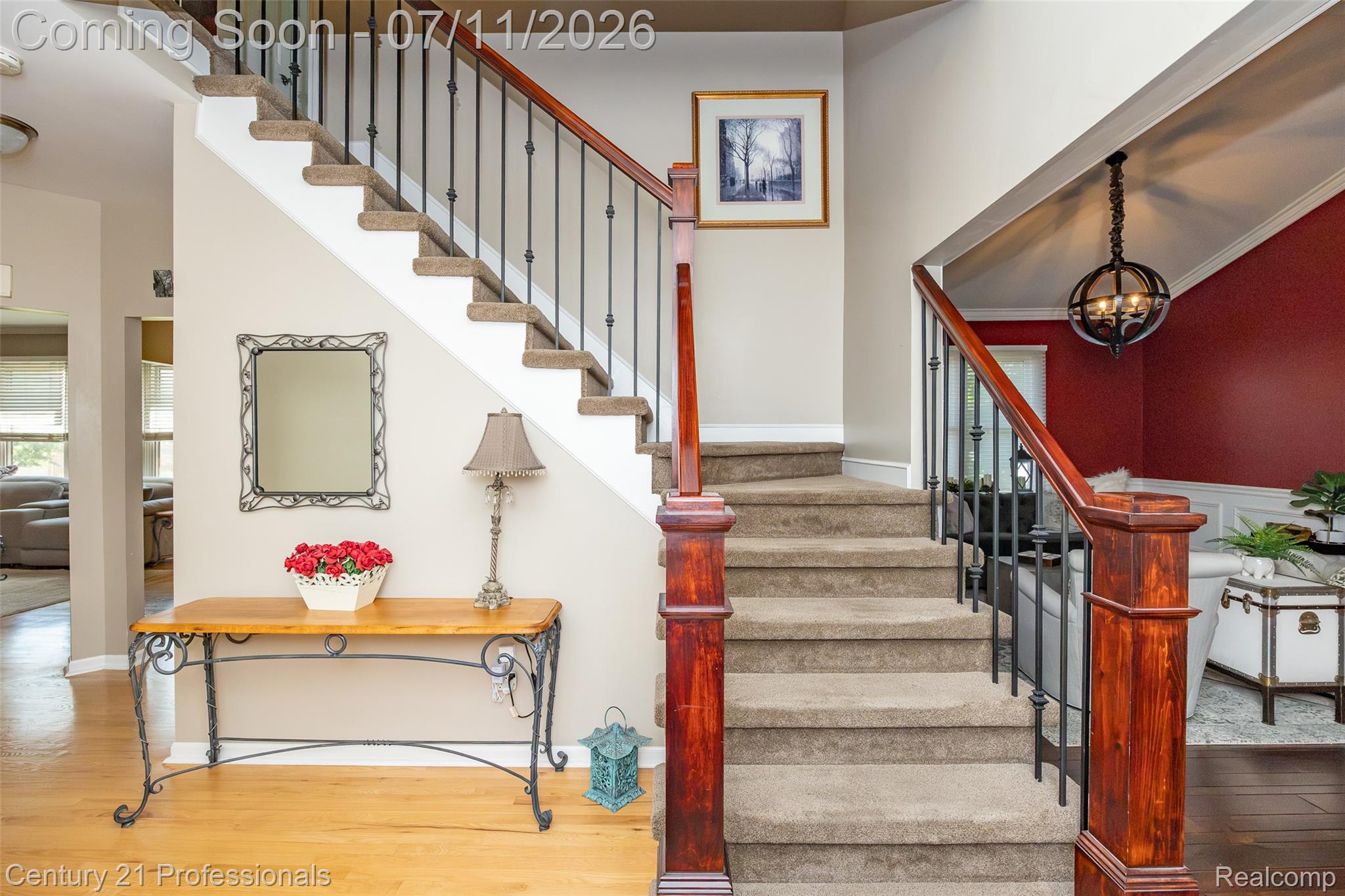 689 Woodfield Way Rochester, MI 48307 - Photo 20 of 61 Carpeted staircase with wood newel posts and handrail, featuring black metal balusters