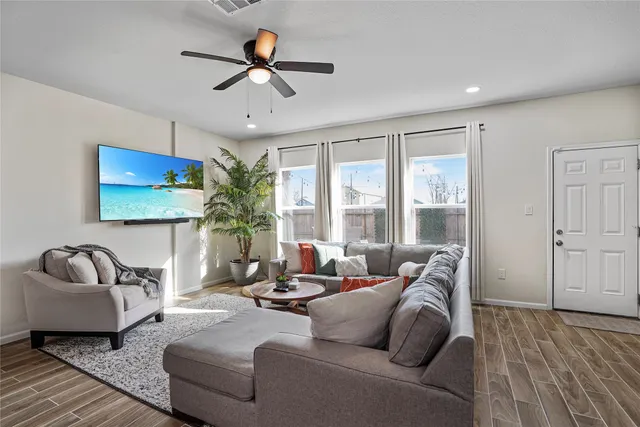 a living room with furniture ceiling fan and a window