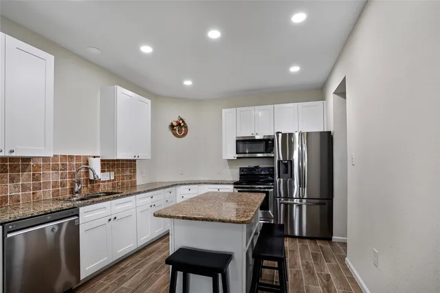 a kitchen with refrigerator cabinets and wooden floor
