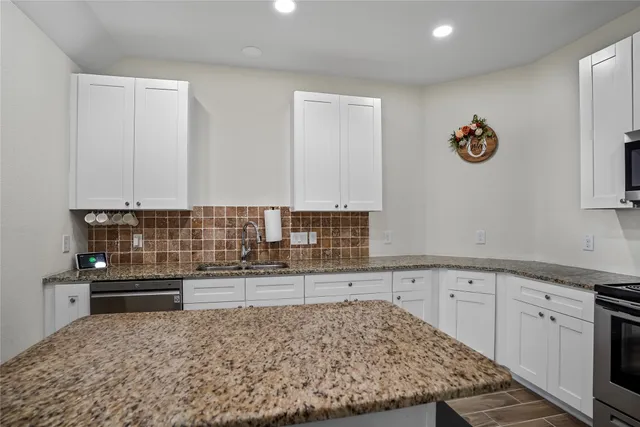 a kitchen with stainless steel appliances granite countertop a sink and cabinets