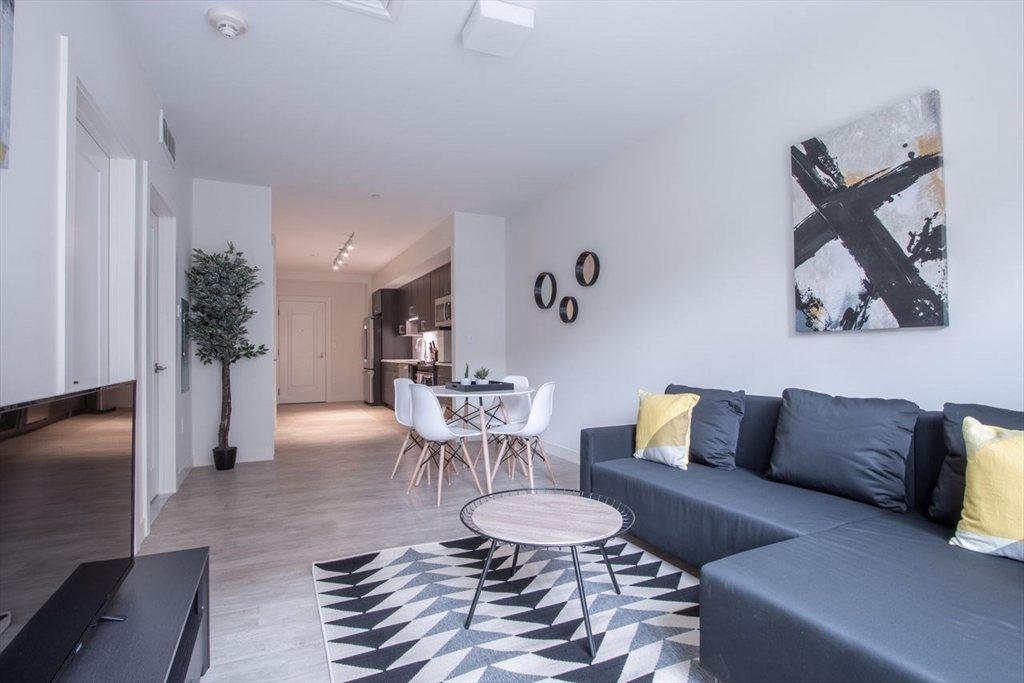 900 Beacon Street, Unit 205 Boston, MA 02215 - Photo 3 of 11 a living room with furniture and a wooden floor