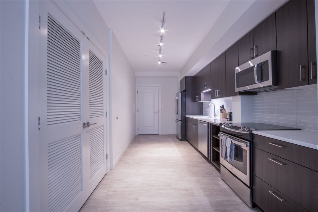 900 Beacon Street, Unit 205 Boston, MA 02215 - Photo 5 of 11 a kitchen with stainless steel appliances granite countertop a stove and a sink