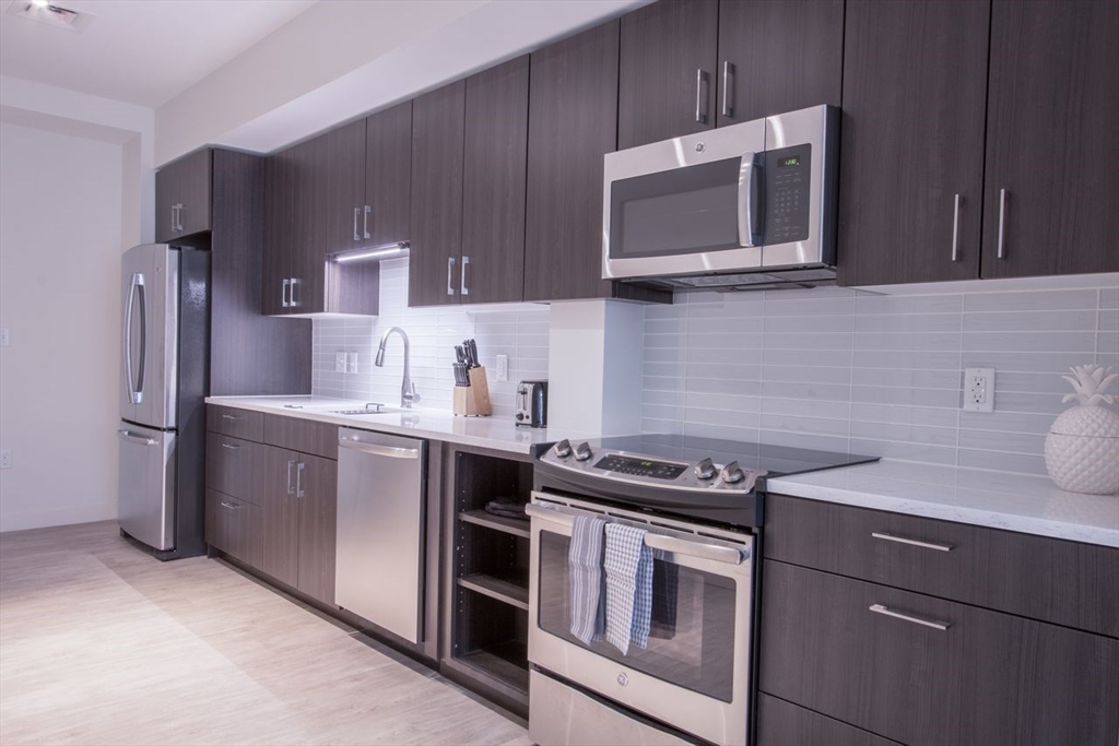 900 Beacon Street, Unit 205 Boston, MA 02215 - Photo 6 of 11 a kitchen with stainless steel appliances a stove microwave and sink
