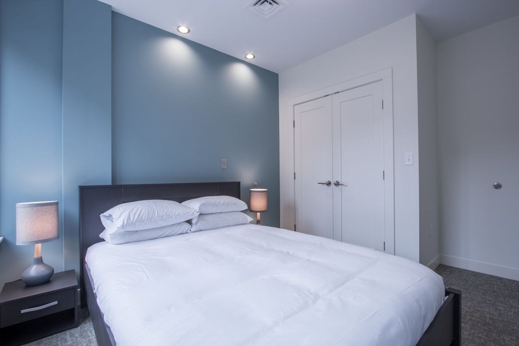900 Beacon Street, Unit 205 Boston, MA 02215 - Photo 8 of 11 a bedroom with a bed and a night stand