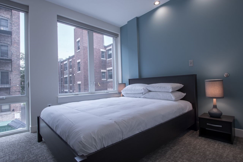 900 Beacon Street, Unit 205 Boston, MA 02215 - Photo 9 of 11 a bedroom with a bed and a lamp