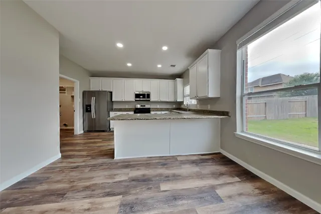a kitchen with stainless steel appliances granite countertop a refrigerator and a stove