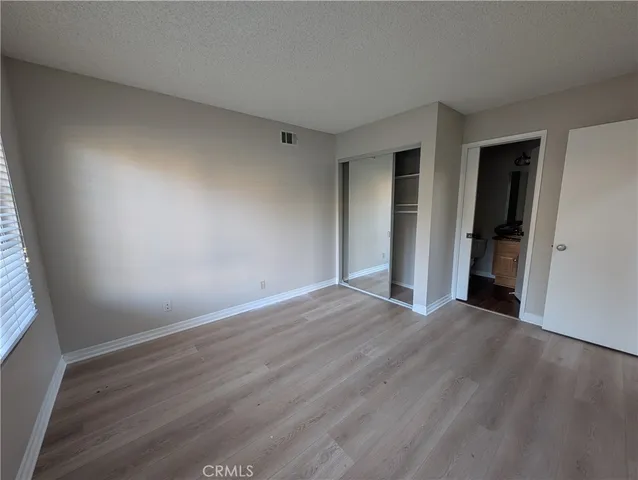 an empty room with wooden floor and closet