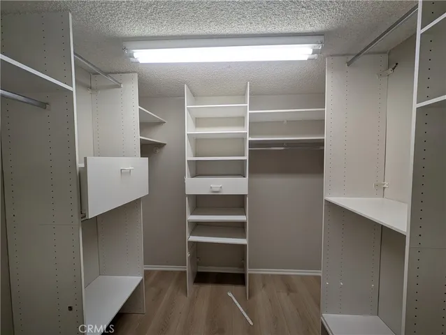 a view of walk in closet with empty racks
