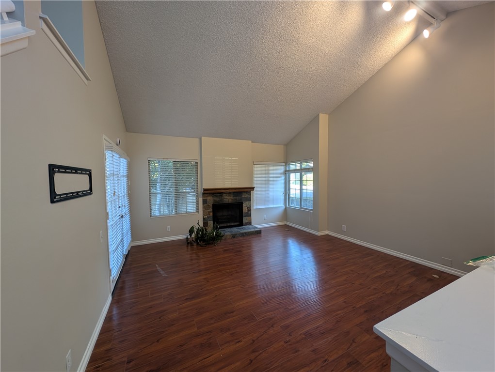 1197 Monte Sereno Drive Thousand Oaks, CA 91360 - Photo 10 of 27 an empty room with wooden floor fireplace and windows
