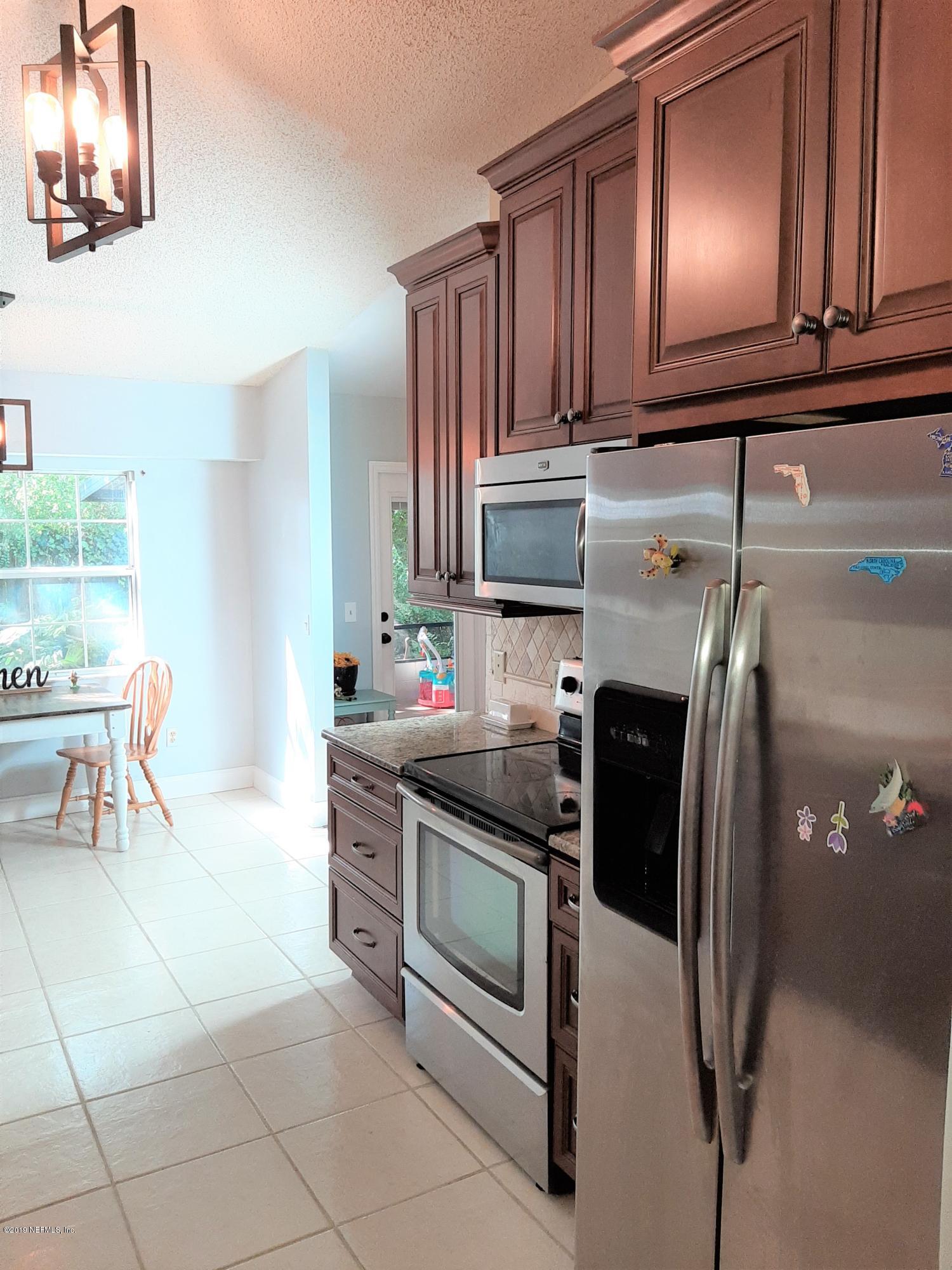 510 Jasmine Road St. Augustine, FL 32086 - Photo 7 of 14 a kitchen with stainless steel appliances granite countertop a stove refrigerator and cabinets