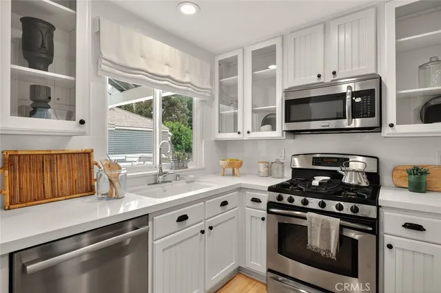 a kitchen with stainless steel appliances a stove microwave and sink