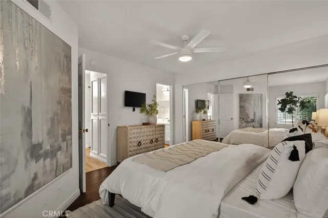 a bedroom with a large bed and a flat screen tv