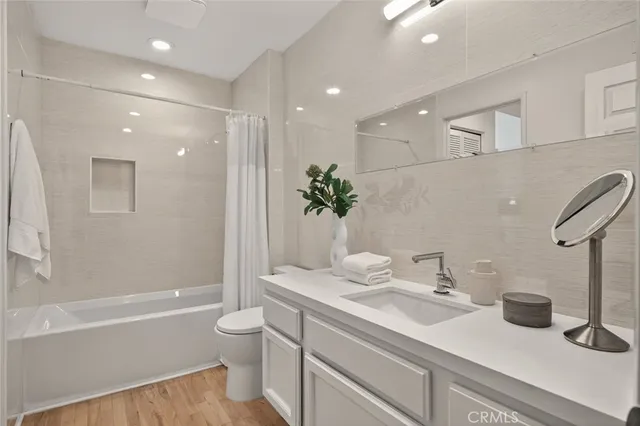 a bathroom with a granite countertop sink a toilet and shower