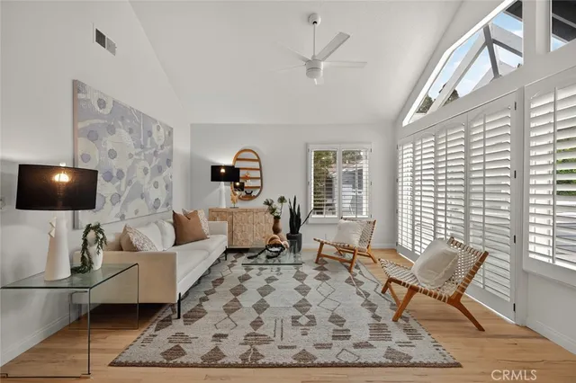 a living room with furniture a rug and a floor to ceiling window