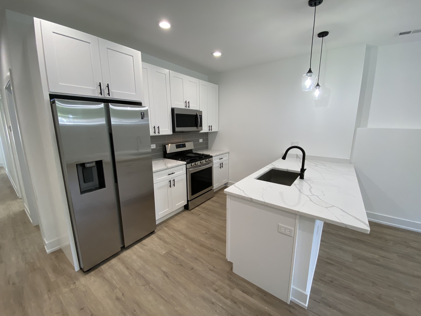 4047 South Prairie Avenue, Unit 2 Chicago, IL 60653 - Photo 2 of 6 a kitchen with stainless steel appliances a refrigerator a sink a stove a microwave a counter top space and cabinets