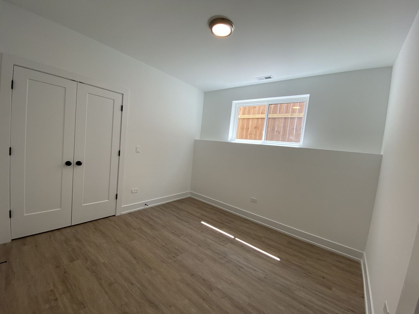 4047 South Prairie Avenue, Unit 2 Chicago, IL 60653 - Photo 6 of 6 a view of an empty room with wooden floor and a window