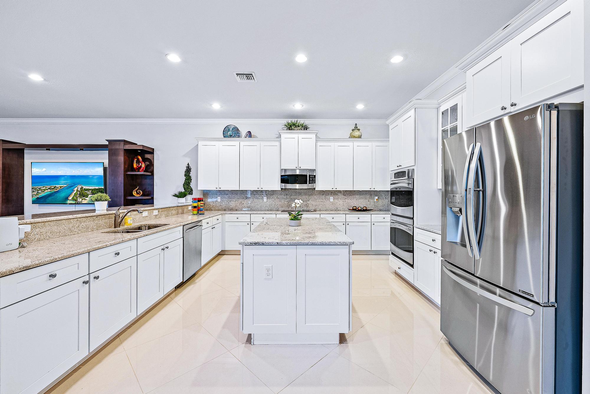 127 Steeple Circle Jupiter, FL 33458 - Photo 10 of 56 a white kitchen with granite countertop a refrigerator oven a sink and white cabinets