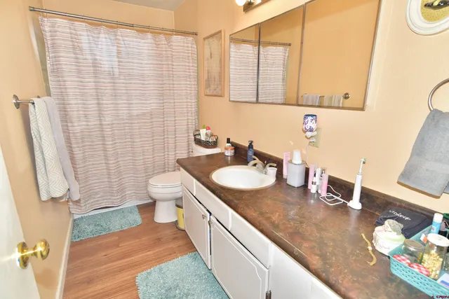 a bathroom with a granite countertop sink and a toilet