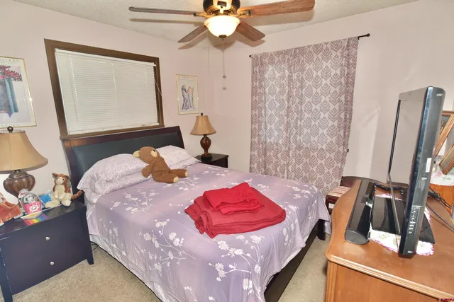 a bedroom with a bed and a mirror on the dresser