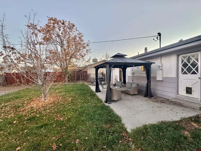 a view of a chair and table in backyard of house