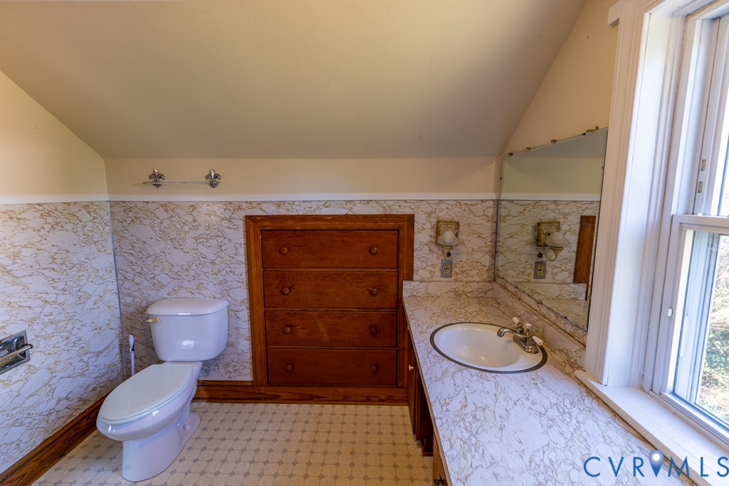 106 Courthouse Road Blackstone, VA 23824 - Photo 23 of 27 a bathroom with a granite countertop toilet a sink and a mirror