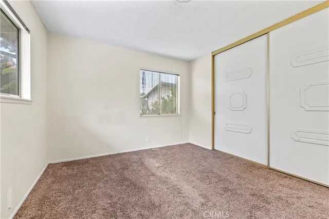 an empty room with windows and closet